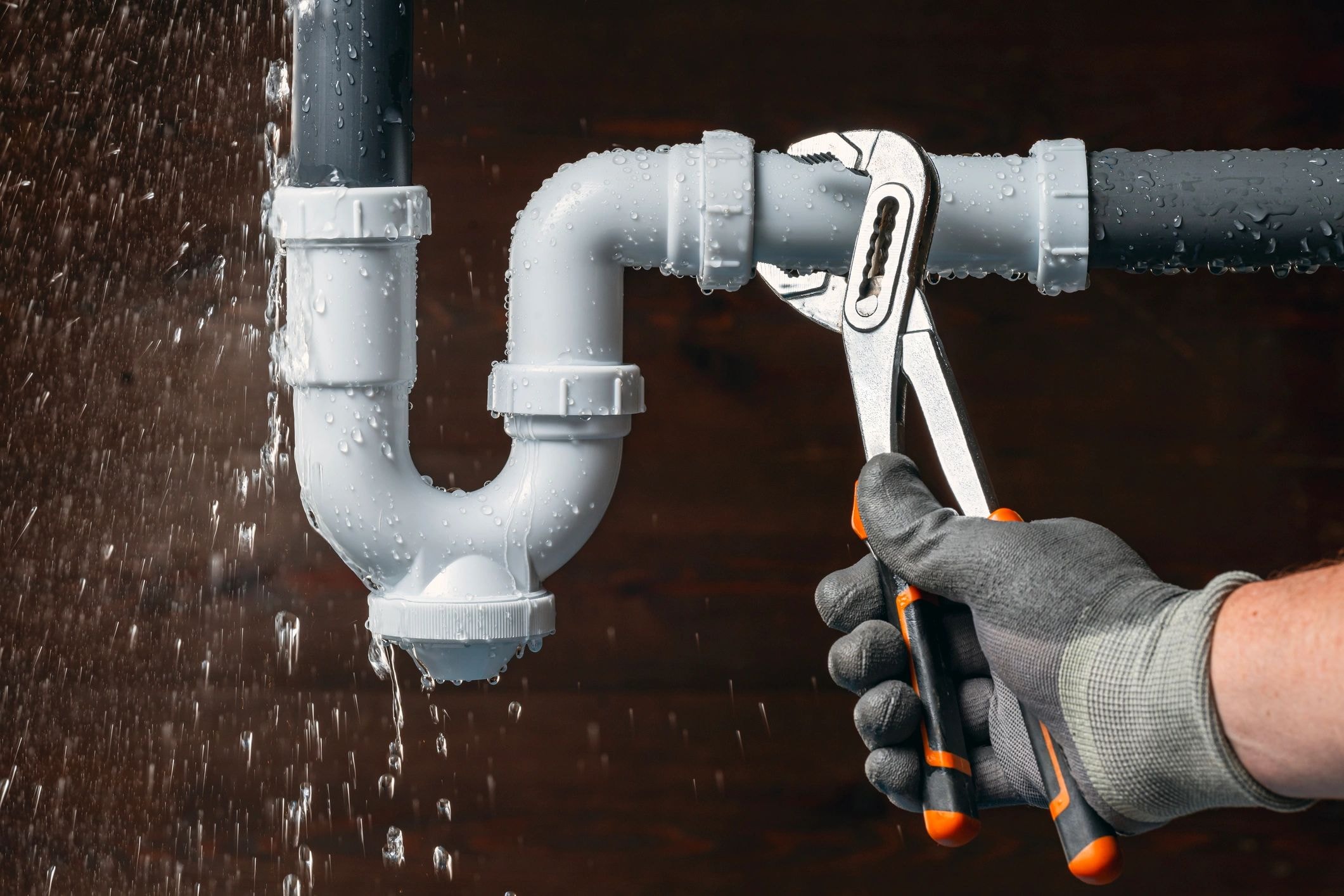 Plumber repairing PVC pipe with wrench